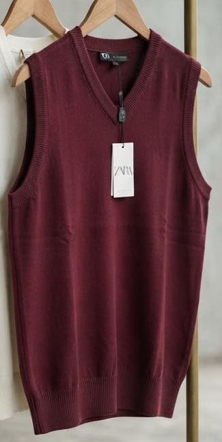 Maroon knit V-neck vest on a hanger